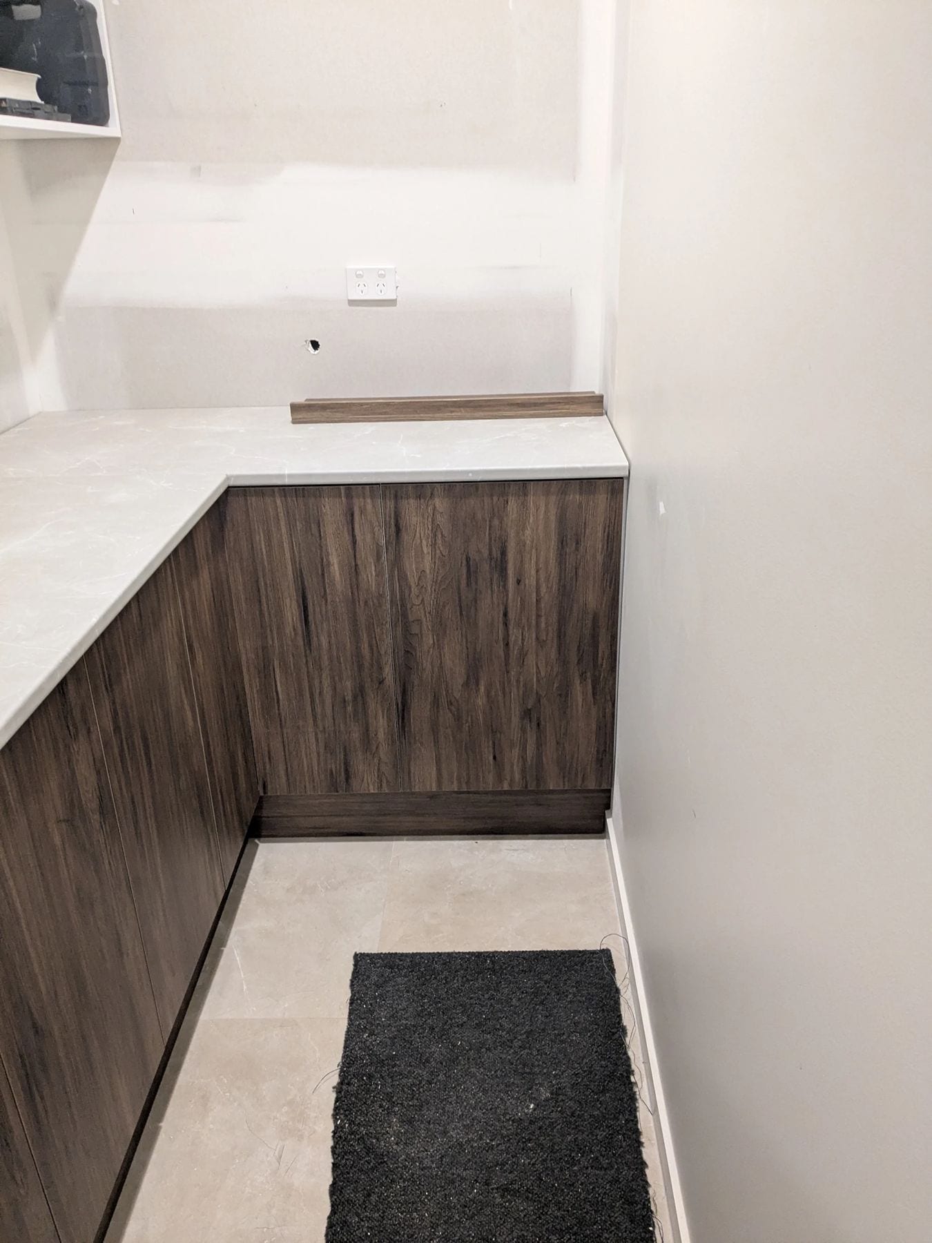 Aged Walnut kitchenette cabinetry with a stone benchtop